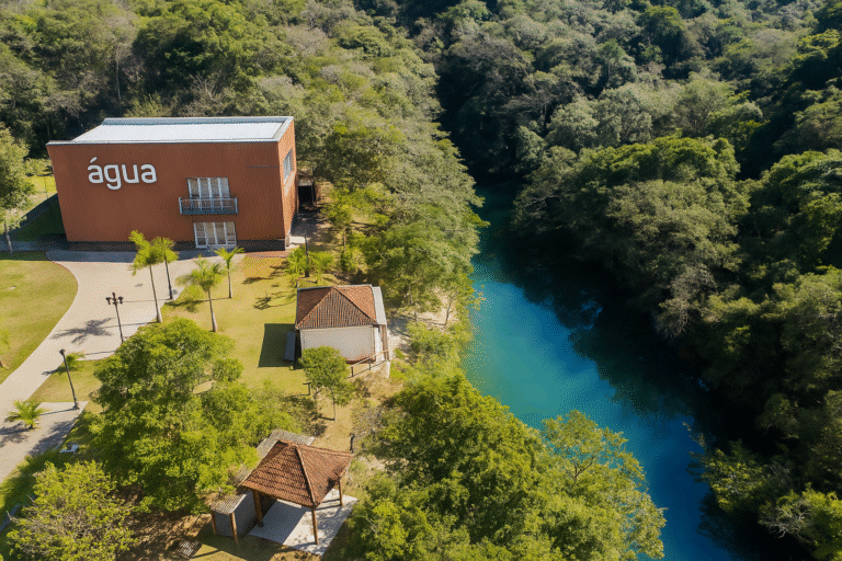 Vista aérea do Museu da Água de Indaiatuba ao lado de um espelho d'água cercado por mata nativa.